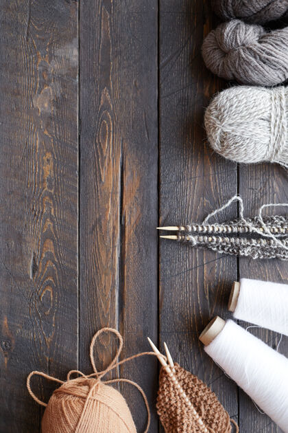 工艺产品木桌上缝纫和针织物品的高角度视图线和毛线以及针织针爱好单品线