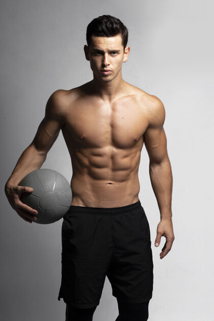 运动员一个英俊的年轻健美强壮的男子裸露胸膛肌肉运动员篮球运动员的正面形象肌肉运动装训练