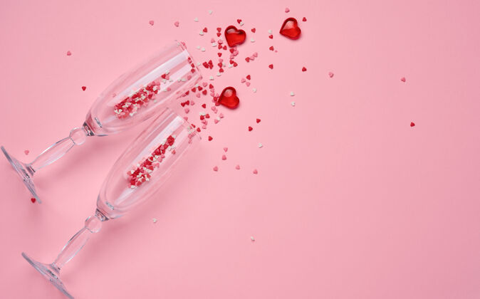 场合两个香槟酒杯 红色心形五彩纸屑和装饰性的心形在粉红色上飞溅背景情人节礼物天概念.top查看 复制空间葡萄酒干杯金色