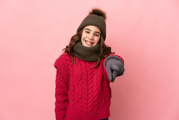 帽子小女孩戴着冬天的帽子 孤立地站在粉色的背景上 脸上露出幸福的表情惊喜年轻女性