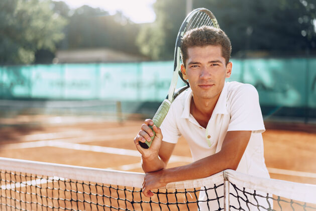 老师站在网球场上的年轻混血男子网球运动员网球场人手