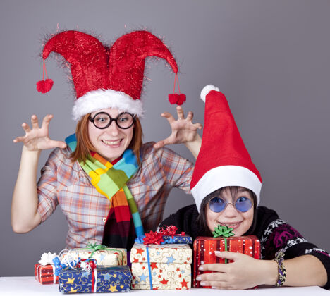 享受两个有趣的女孩过圣诞节礼品工作室射击携带乐趣帽子