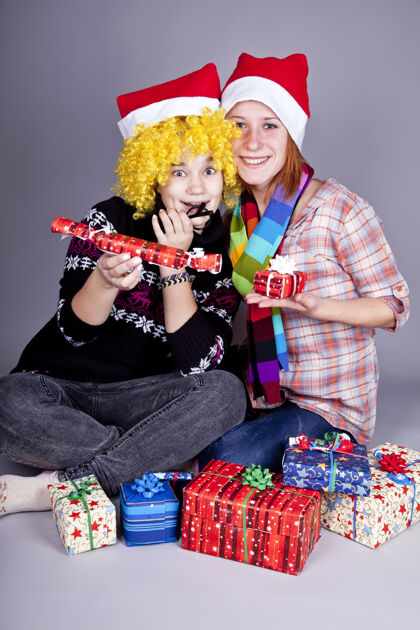 圣诞老人两个有趣的女孩过圣诞节礼品工作室射击女孩礼物帽子