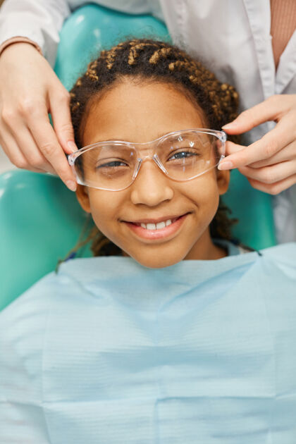 护士照片中的小女孩躺在牙医的椅子上 在体检时面带微笑特写体检专业知识