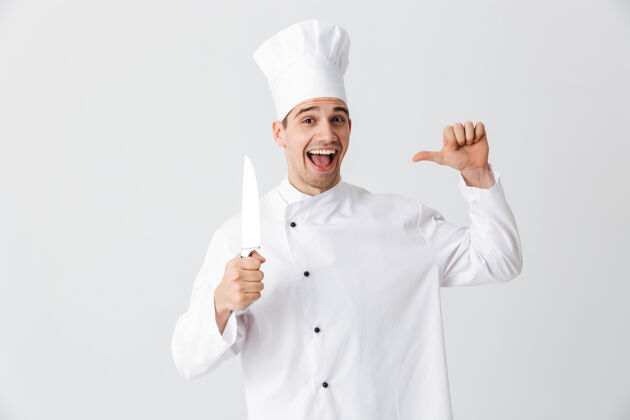 制服快乐厨师厨师穿着制服拿着刀隔着白墙饮食酒店厨师