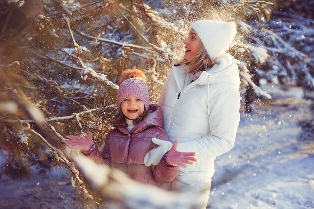 公园妈妈和女儿在冬季公园玩得很开心幼儿户外快乐