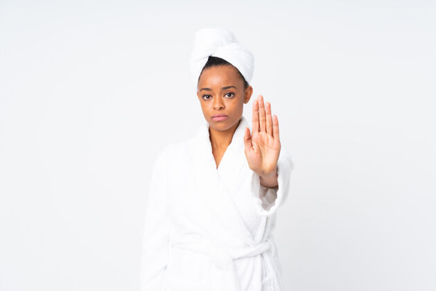 女人一个穿着浴衣的非裔美国女人用手做了个停车的手势洗澡舒适浴袍