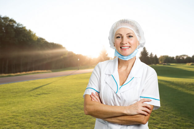 护士微笑的女外科医生交叉双臂快乐的女外科医生交叉双臂站在大自然上脸医院保健