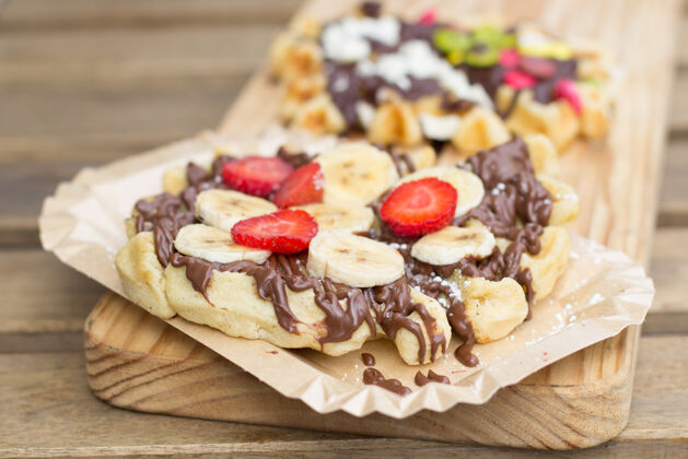 甜点比利时华夫饼 上面有巧克力奶油和新鲜水果 香蕉和草莓甜食草莓一餐