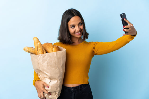 食物一个年轻的拉丁女人在买面包 自拍黑发Bakehouse厨房