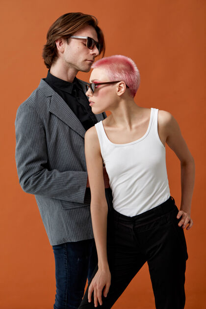 成人时尚的年轻潮人性感的女人和戴着太阳镜的男人 一起摆姿势粉色头发模特情侣