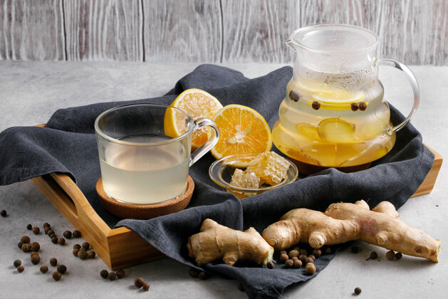 玻璃茶壶里放着姜根和柠檬片透明香气饮料