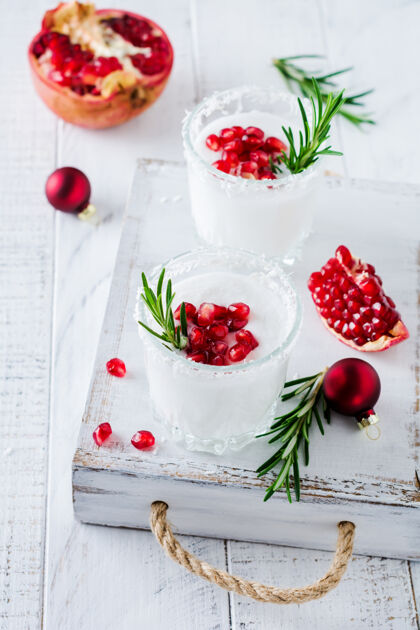 玻璃杯圣诞椰子酒配石榴籽和迷迭香小枝 表面光亮食谱利口酒节日