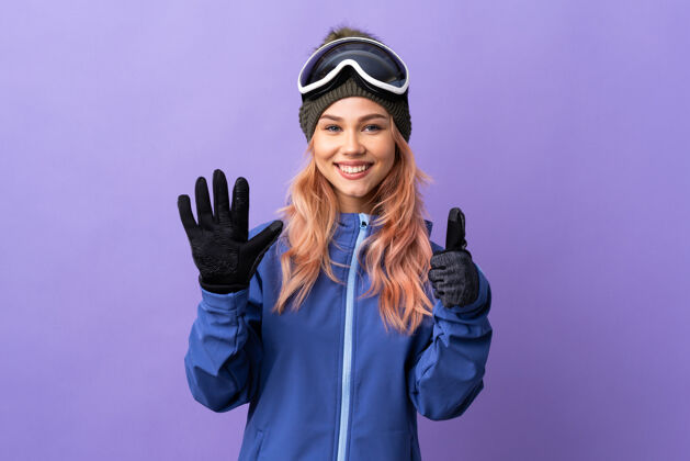 旅行滑雪女孩戴着滑雪板上的眼镜 用手指数着6个数字女成功