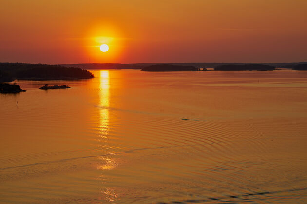 黄昏纳坦塔利的金色夕阳 芬兰.反思太阳落在地上水副本空间鸟分享海洋