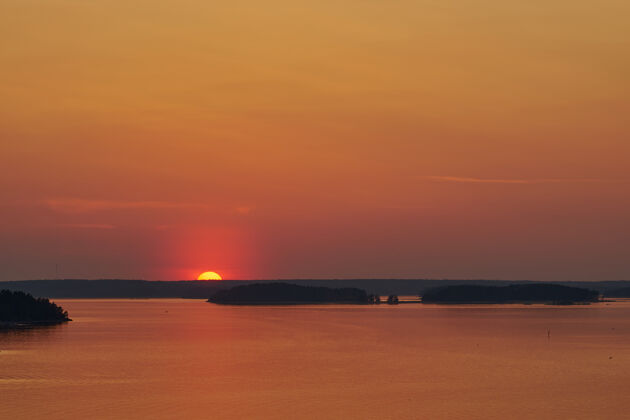 宁静纳坦塔利的金色夕阳 芬兰.反思太阳落在地上水副本空间飞行海滩湖泊