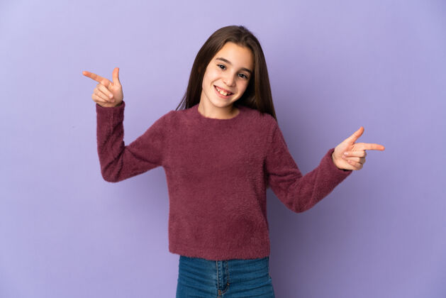小小女孩孤零零地在紫色的墙上用手指着枝桠 高兴极了模型产品手势