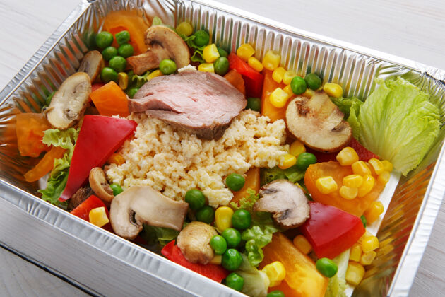 美食把食物放在锡箔盒里带走白木蒸粗麦粉配蘑菇 火鸡肉和蔬菜食物盒子餐具