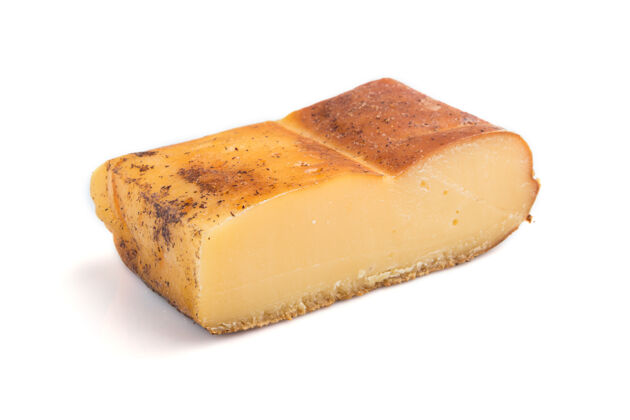 切割一块被隔离在白色表面的烟熏奶酪帕尔马干酪传统牛奶