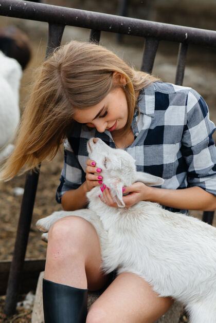 有机一个年轻漂亮的女孩和山羊以及其他动物在牧场上摆姿势农业 畜牧业牲畜绵羊生态