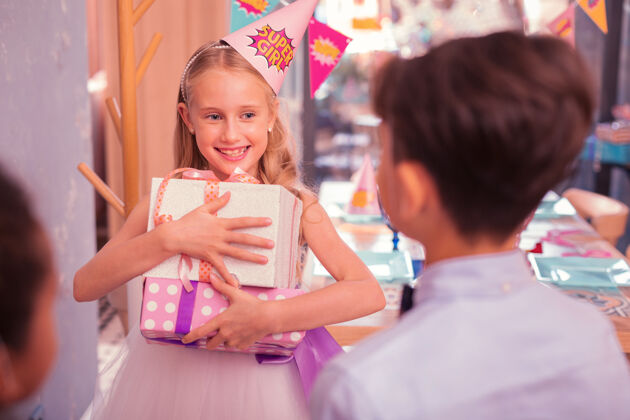 积极生日快乐女孩积极的生日女孩感觉印象深刻的礼物和微笑给她的朋友派对帽可爱咖啡馆