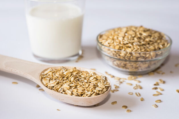 自然燕麦片和一杯牛奶放在白色的表面上素食燕麦谷物