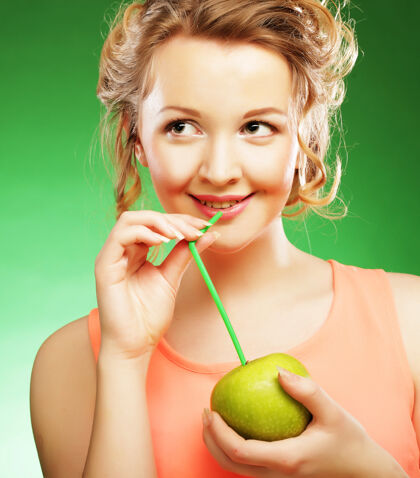 抗氧化剂带着苹果和草莓鸡尾酒的年轻快乐微笑的女人苹果欧洲快乐