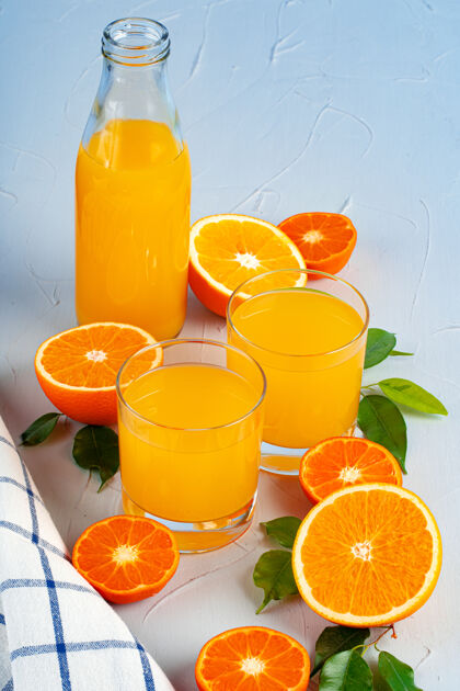 瓶装桌上摆着一瓶橙汁和新鲜橙子刷新热带食品