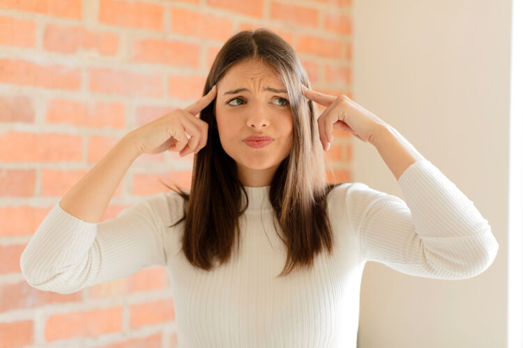 女性感到困惑或怀疑 专注于一个想法 认真思考 想复制旁边的空间砖墙思考智能