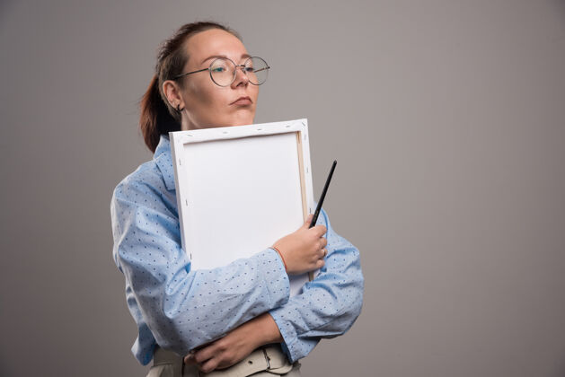 列表一个女人抱着一块灰色的空画布情感眼镜画笔