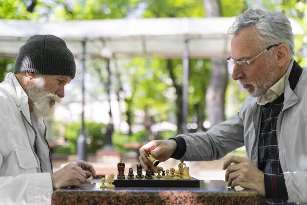 老年人近距离观察下象棋的人特写生活方式户外