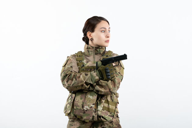 私人前视图：白墙上带枪的伪装女兵女人白