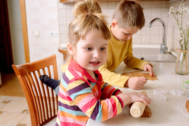 揉有趣的孩子在家里烤饼干厨房快乐家庭年轻面团桌子