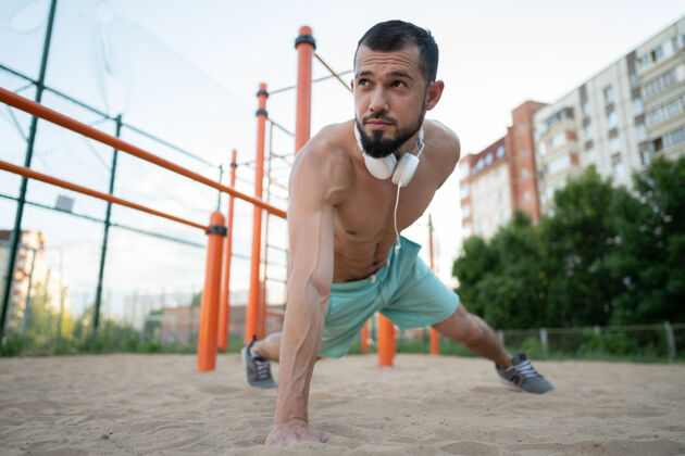 健康的生活方式一个年轻运动员在沙滩上用一只手做俯卧撑夏季运动 健身 街头运动概念运动俯卧撑活跃