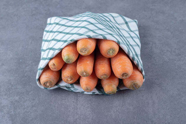 毛巾胡萝卜裹在毛巾里 放在大理石表面新鲜生的蔬菜