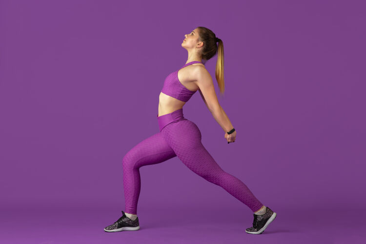 体重伸展运动美丽的年轻女运动员在练习 单色紫色肖像运动型白种人适合模型训练健身 健康的生活方式 美丽和行动的概念单色广告准备