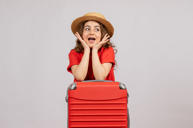肖像正面图：站着手提箱的年轻女子站着女人度假