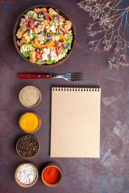 膳食俯瞰美味蔬菜沙拉搭配不同调味料的深色背景健康饮食蔬菜沙拉午餐午餐不同晚餐