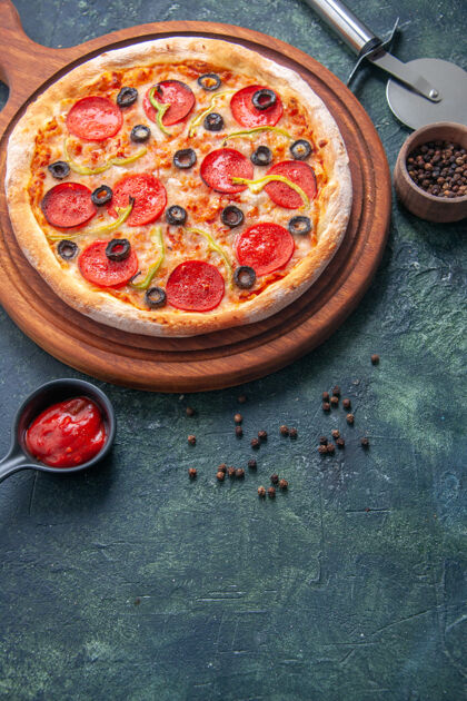 切美味的比萨饼放在木制砧板上 胡椒番茄酱放在独立的黑暗表面上 俯视图番茄酱晚餐美味