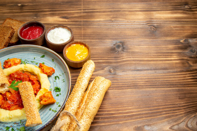 食物正面图美味的鸡肉片 土豆泥和面包放在木桌上 土豆饭 辣椒胡椒玉米晚餐