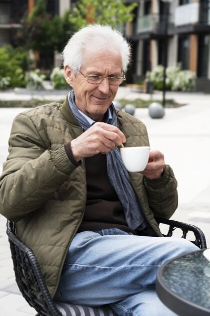 男人城里的老人在喝咖啡老年人老年人户外
