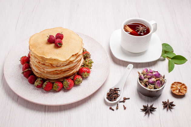 草莓正面是美味的草莓煎饼和一杯茶餐甜点刷新