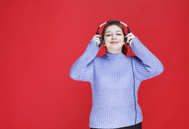 智能戴着耳机听音乐的女孩员工促销女性