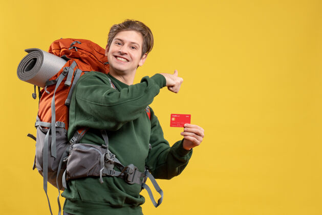 旅行者正面图年轻男子手持银行卡准备远足情感年轻男性黄色