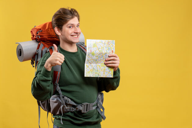 旅游正面图年轻男子背着背包拿着地图人黄色年轻的男性