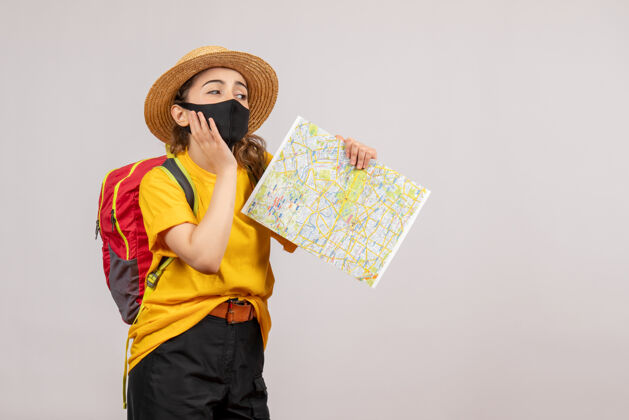 人前视图年轻女子背着背包举着地图冒险流行病度假