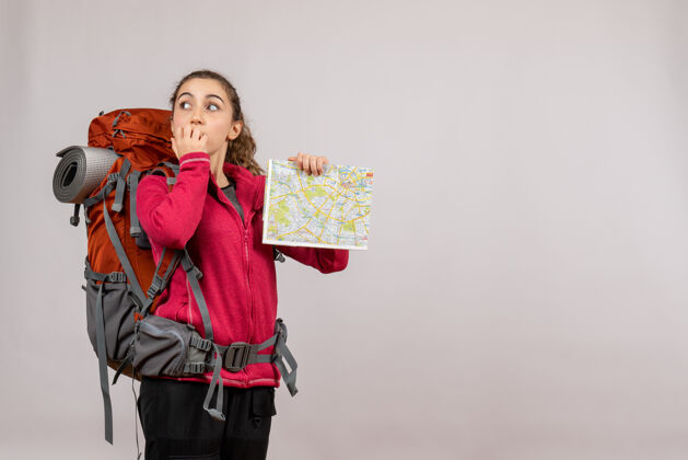 年轻的旅行者前视图年轻的旅行者与大背包举行地图美丽旅游女人