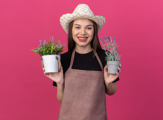 微笑笑容可掬的白人女园丁戴着园艺帽拿着花盆园艺举行帽子