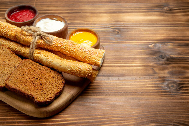 肉正面图深色面包面包 棕色桌子上有面包和调味品 食物面包 面包 辛辣晚餐馒头调味品