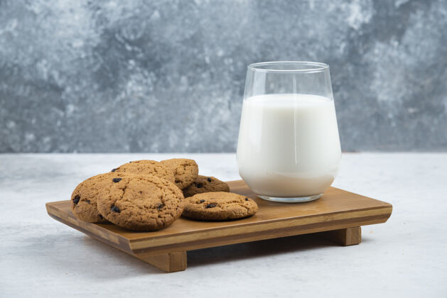奶制品木制书桌上放着一杯巧克力饼干棕色烘焙牛奶